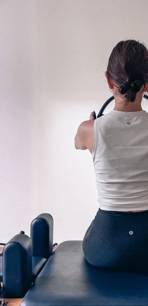 札幌・円山公園エリアのピラティス美姿勢スタジオで、マシンピラティスで背中を伸ばす女性
